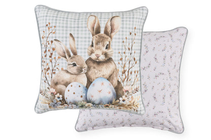 Cuscino pasquale Nuvole di Stoffa in cotone con sfondo celeste a quadretti vichy e retro con cuiricini. Decorazione con illustrazioni di coniglietti, uova colorate e fiori delicati. Elegante tessile per Pasqua 2026.