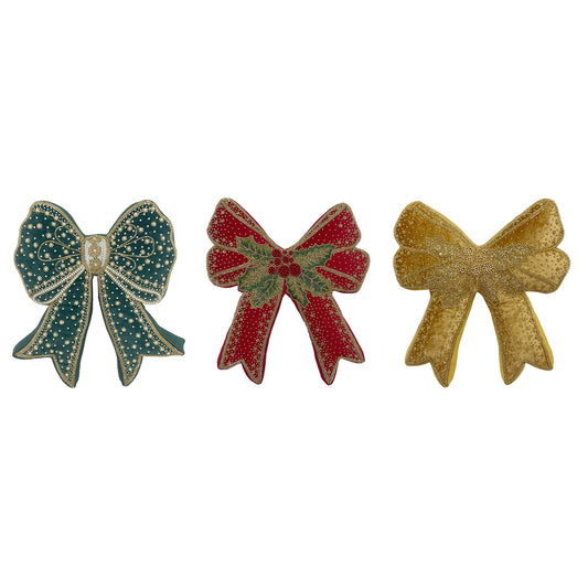 Tris di cuscini sagomati a forma di fiocco natalizio Blanc Mariclò. Modelli in velluto verde bosco, rosso con agrifoglio e oro senape, tutti impreziositi da ricami e perline lucenti.