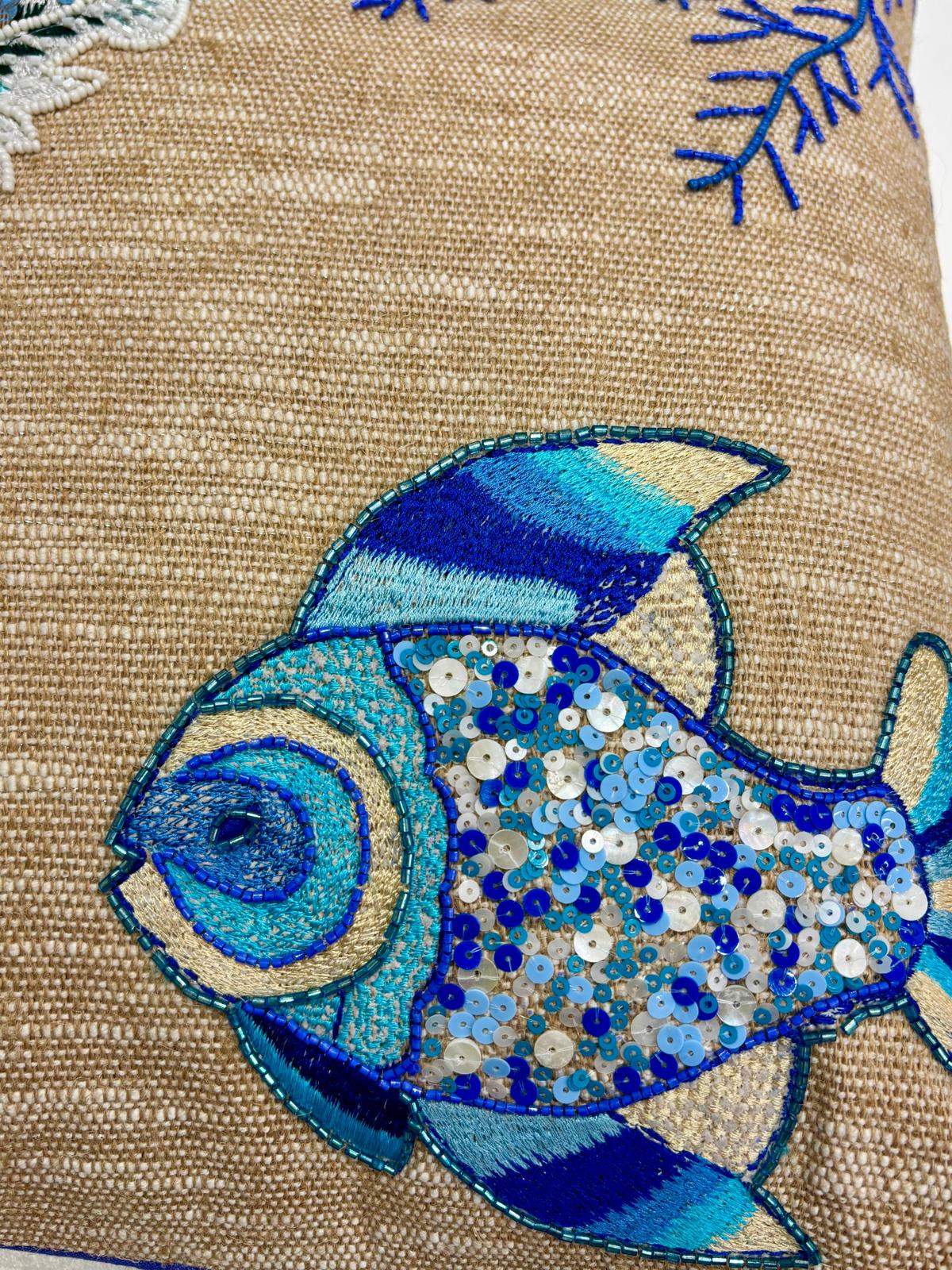 Dettaglio del Cuscino Blanc Mariclo' linea Maldive in lino naturale color beige. Stampa marina con pesci ricamati blu. Complemento d'arredo per case estive.