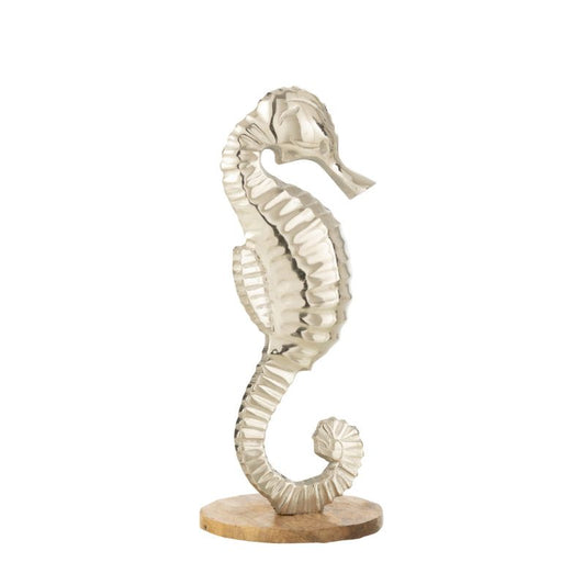 Decorazione a forma di cavalluccio marino in alluminio lucido della linea "Oceano Azul", posizionato su una base circolare in legno chiaro. Questa scultura ornamentale in stile marino è ideale come soprammobile per abbellire mobili, mensole o consolle della zona giorno.