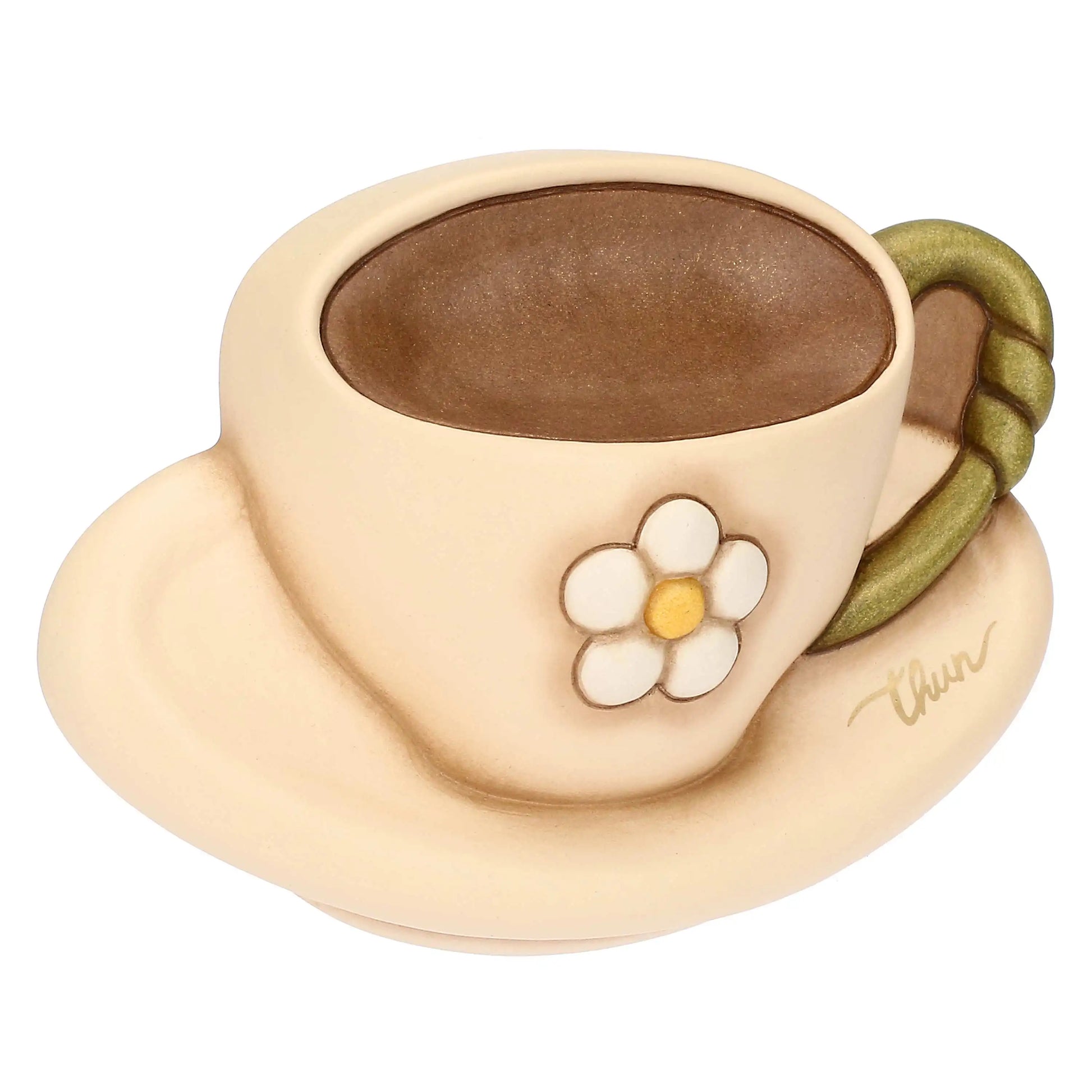 Formella decorativa da parete in ceramica firmata Thun, sagomata a forma di tazzina da caffè con piattino nei delicati toni del beige e del marrone. Questo articolo della linea Country Bloom presenta un fiore bianco a rilievo al centro, un manico verde e il classico marchio Thun dorato sul piattino.