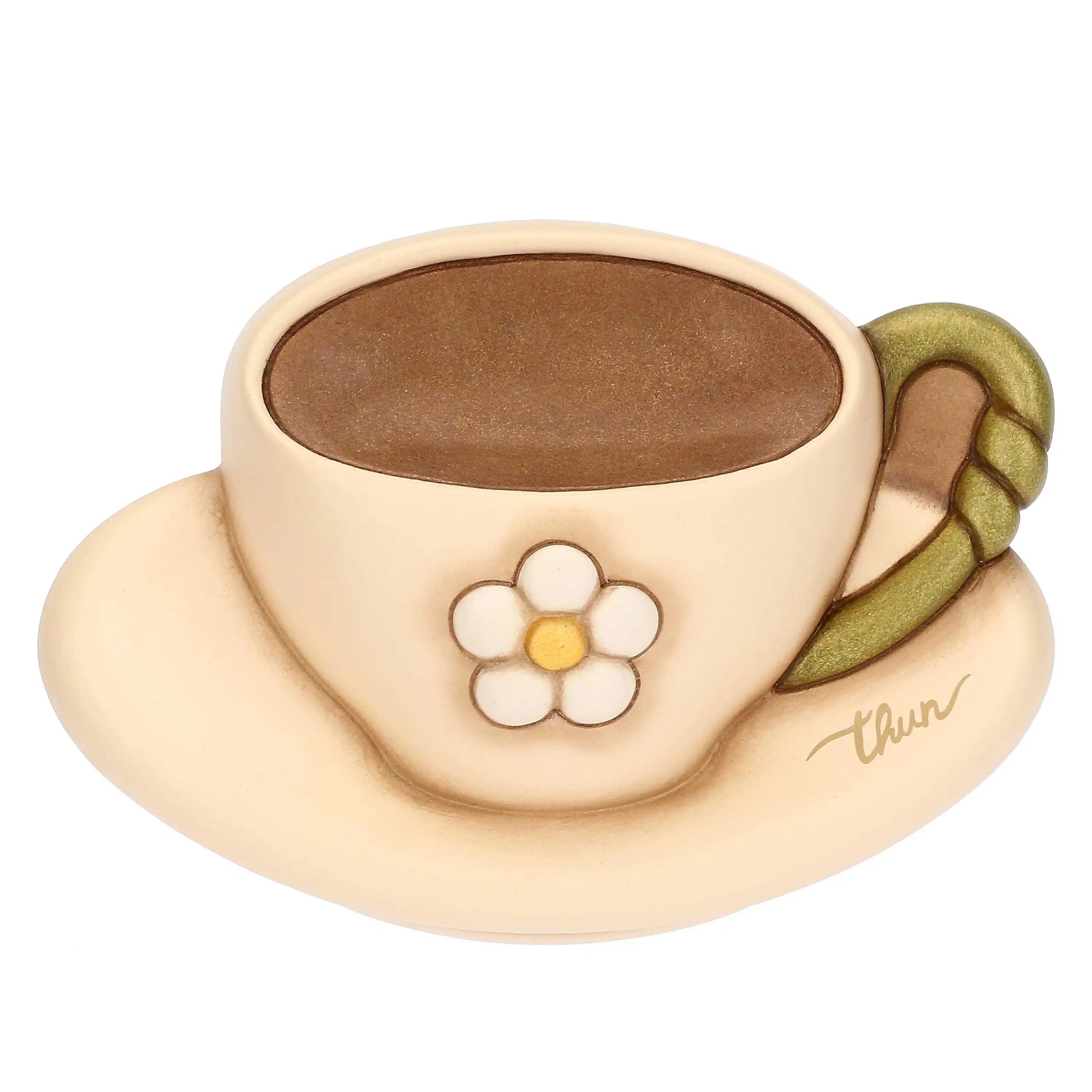 Formella decorativa da parete in ceramica firmata Thun, sagomata a forma di tazzina da caffè con piattino nei delicati toni del beige e del marrone. Questo articolo della linea Country Bloom presenta un fiore bianco a rilievo al centro, un manico verde e il classico marchio Thun dorato sul piattino.