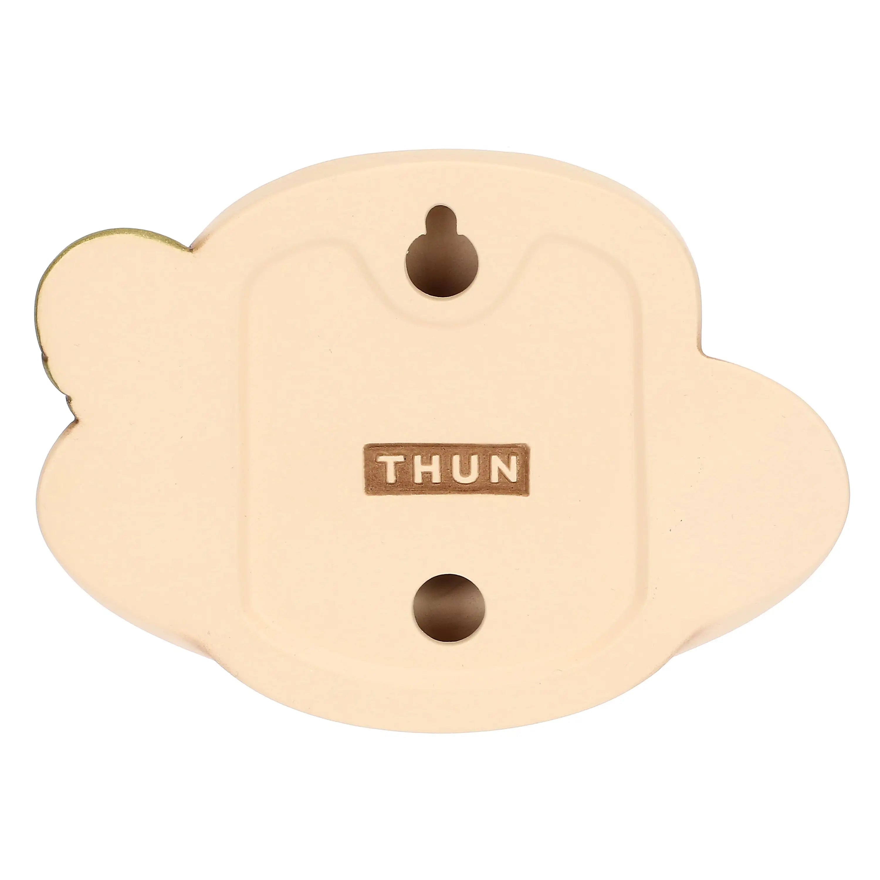 Formella decorativa da parete in ceramica firmata Thun, sagomata a forma di tazzina da caffè con piattino nei delicati toni del beige e del marrone. Questo articolo della linea Country Bloom presenta un fiore bianco a rilievo al centro, un manico verde e il classico marchio Thun dorato sul piattino.