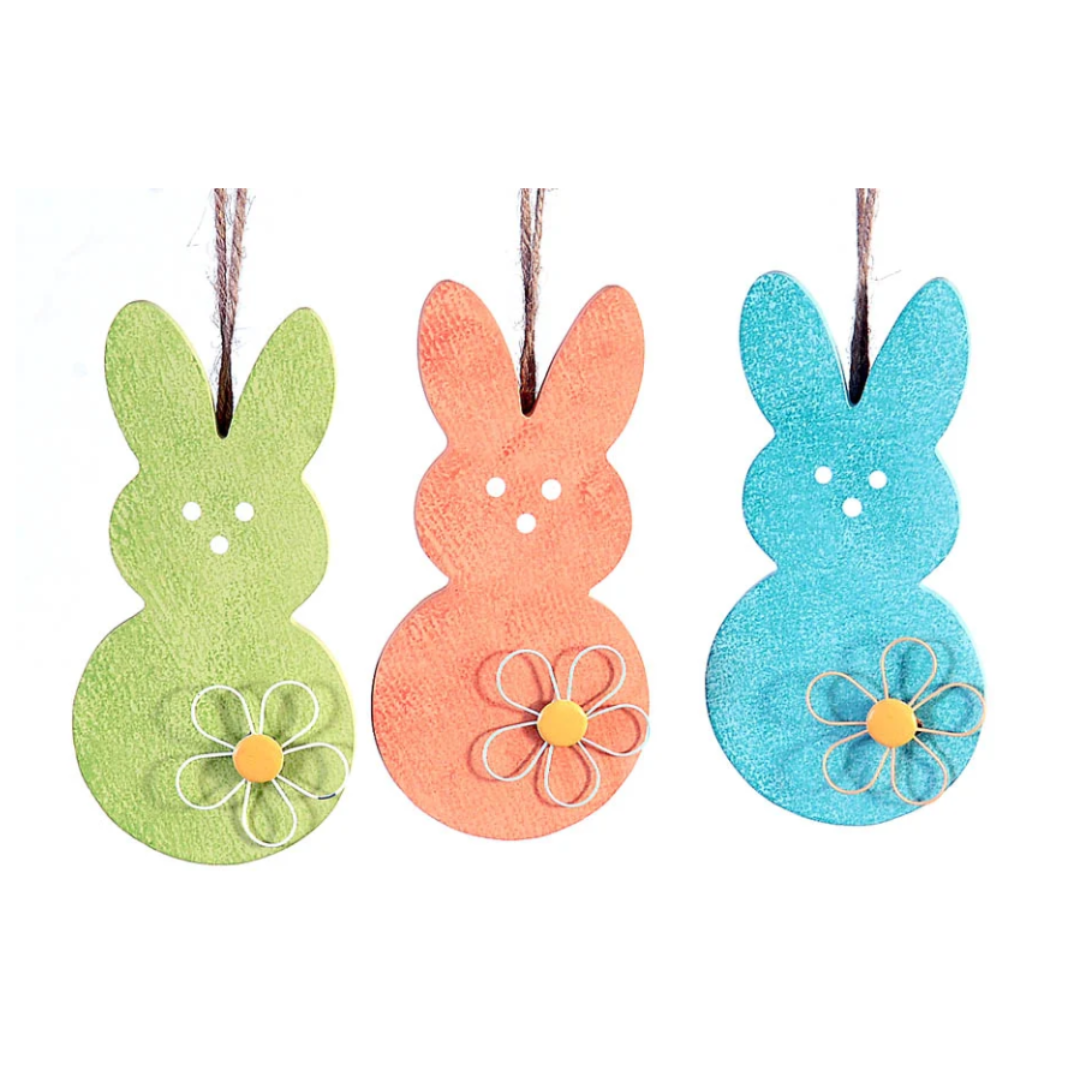 Tris di decorazioni pasquali pendenti in legno a forma di sagoma di coniglio. Il set comprende tre colori assortiti con finitura materica: verde mela, arancione e azzurro. Ogni coniglio è decorato con un fiore stilizzato in rilievo sulla base e presenta tre piccoli fori che disegnano il muso; sono appesi a un cordino di juta naturale.