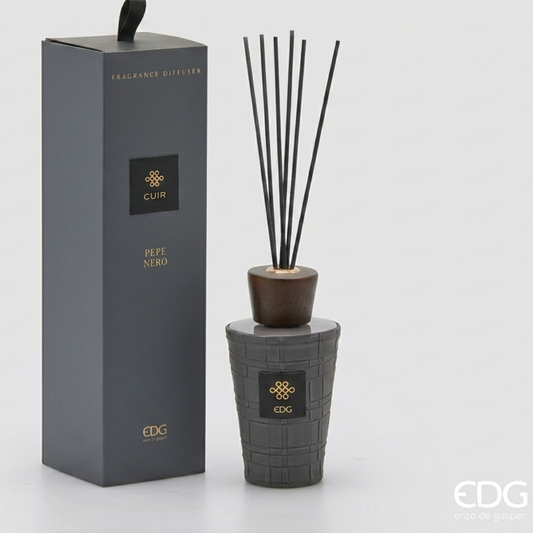 Il Diffusore per Ambienti Cuir Pepe Nero EDG è un set di lusso composto da una raffinata bottiglia dal design materico grigio antracite con finitura intrecciata, completata da un tappo in legno scuro e bastoncini neri. La confezione regalo a colonna coordinata con dettagli dorati racchiude questa intensa fragranza speziata, rendendola un complemento d'arredo perfetto per l'home decor maschile o di tendenza.