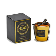 Candela profumata "Mirror" in bicchiere di vetro oro specchiato firmata EDG Enzo de Gasperi alla fragranza Champagne, decorata sulla parte superiore con un elegante nastro nero e scritte dorate. Questa esclusiva candela decorativa di lusso è accompagnata dalla sua scatola regalo nera con finiture color oro, ideale per profumare gli ambienti di casa e creare un'atmosfera calda, accogliente e ricercata.