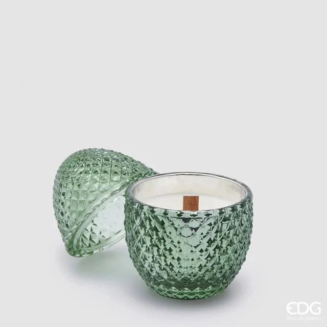 Candela profumata "L'Ove" alla fragranza Fig & Gardenia firmata EDG Enzo de Gasperi, caratterizzata da un elegante contenitore in vetro verde acqua lavorato a rilievo a forma di uovo con coperchio coordinato e stoppino in legno. Questa raffinata candela decorativa di lusso è accompagnata dalla sua confezione regalo in tinta con motivi geometrici, ideale per profumare gli ambienti di casa con stile o come originale idea regalo home decor.