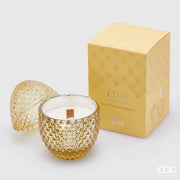 Candela profumata "L'Ove" alla fragranza Ginger & Warm Vanilla firmata EDG Enzo de Gasperi, caratterizzata da un elegante contenitore in vetro giallo ambrato lavorato a rilievo a forma di uovo con coperchio coordinato e stoppino in legno. Questa raffinata candela decorativa di lusso è accompagnata dalla sua confezione regalo gialla con motivi geometrici, ideale per profumare gli ambienti di casa con stile o come originale idea regalo home decor.