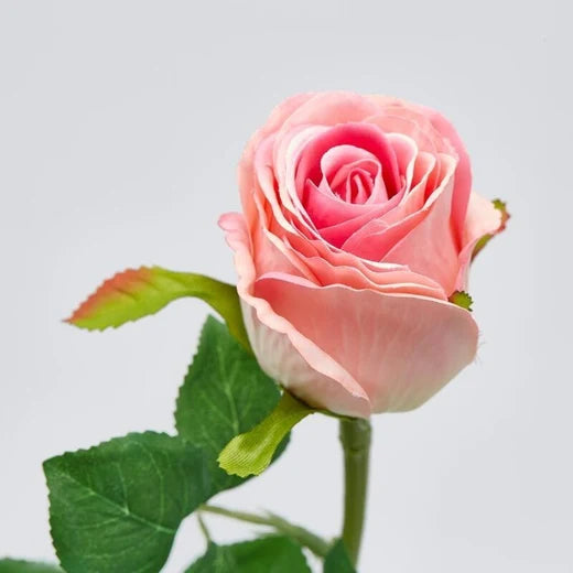Ramo di rosa artificiale a bocciolo in tonalità assortite rosa e fucsia, con foglie verdi dentellate dai bordi rossastri. Elemento decorativo floreale, ideale per l’home décor e come idea regalo.