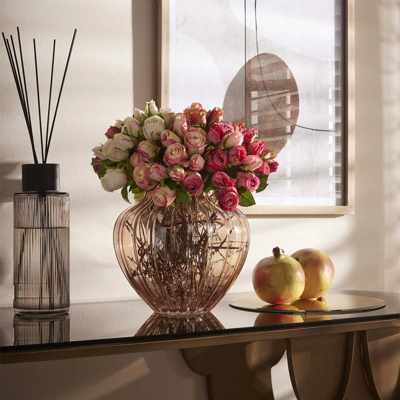 Mazzo di rose artificiali dai petali sfumati malva e fucsia, con foglie verdi seghettate e legatura in rafia naturale. Composizione floreale artificiale dal effetto bicolore, ideale per l’home décor e come idea regalo.