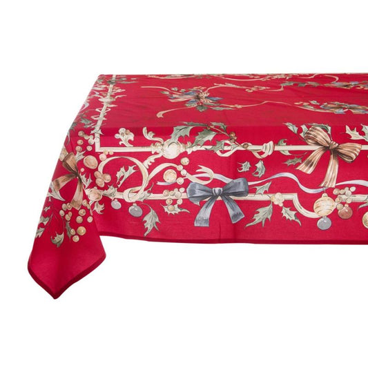 Foulard centrotavola Blanc Mariclo' Intrecci di Sogno steso su un tavolo. Il bordo è rifinito con un motivo a ghirlanda natalizia, grandi fiocchi azzurri, bacche dorate e foglie di agrifoglio.