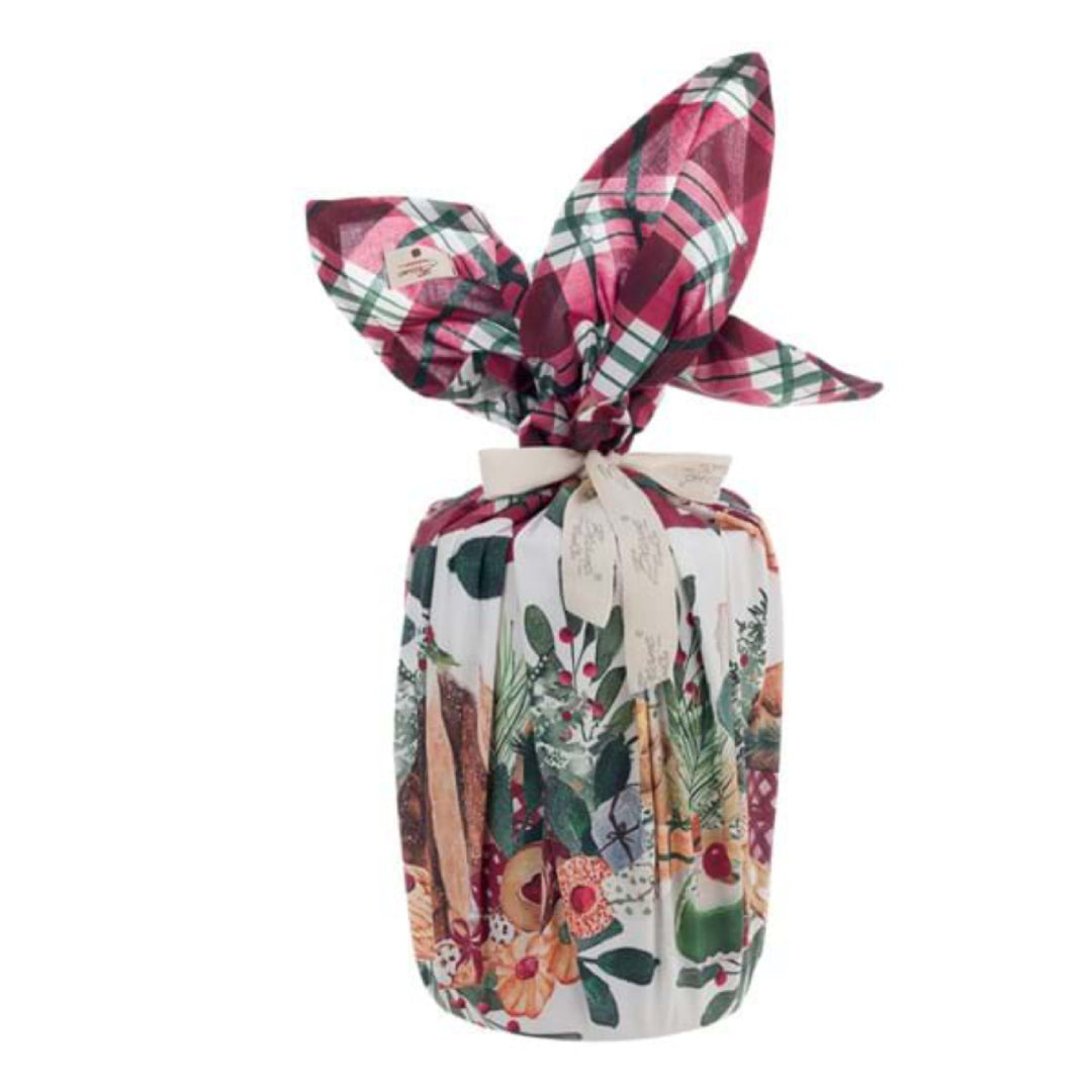 Foulard natalizio Blanc Mariclò serie "La Patisserie" annodato intorno a un panettone. Il tessuto presenta una ricca stampa di dolci tipici e ghirlande, rifinito da un nodo a fiocco e un nastro logato color panna.