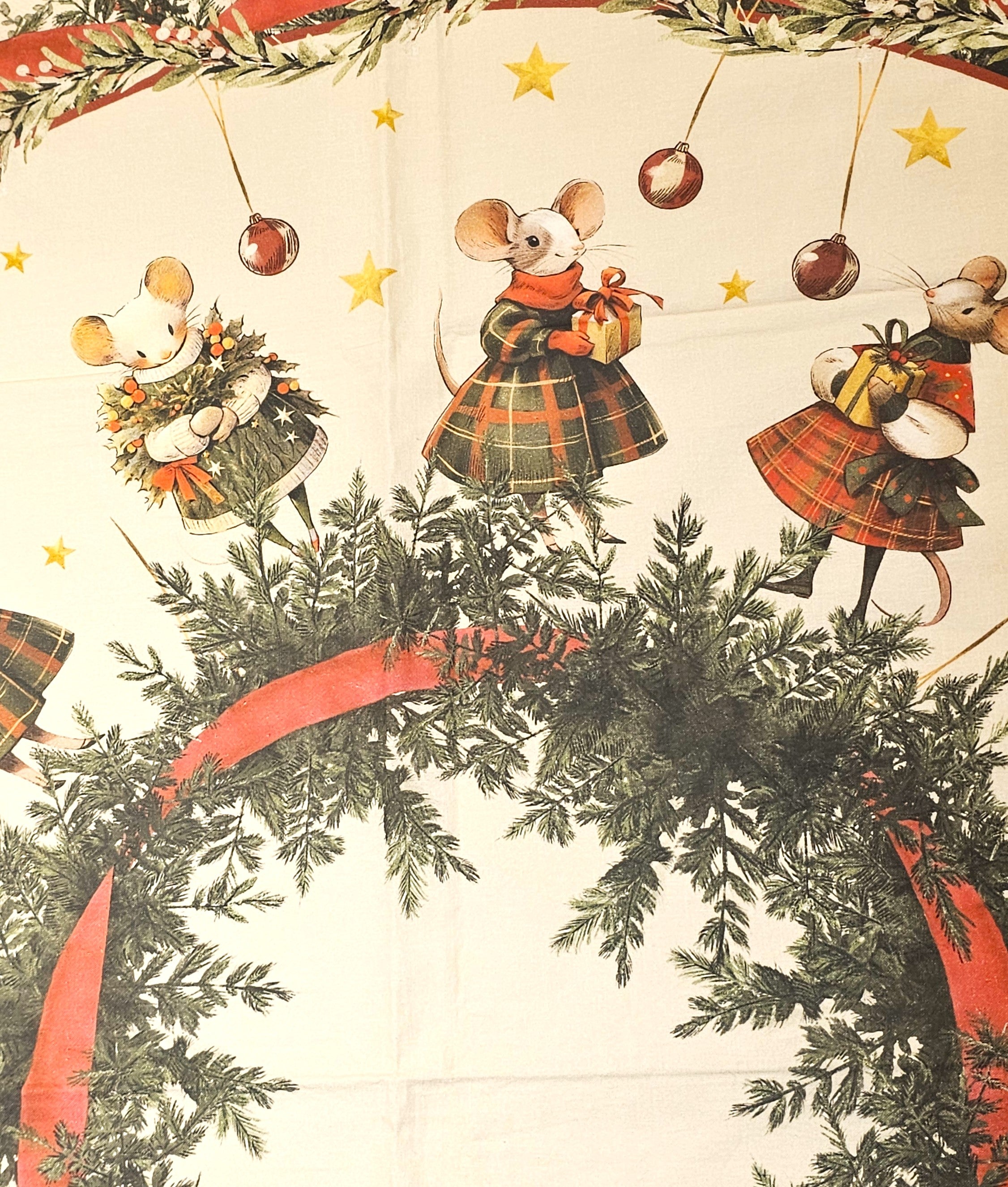 Zoom della stampa sul foulard: topini con doni e ghirlande camminano sopra una grande ghirlanda circolare decorata con un nastro rosso. Sullo sfondo, stelle dorate e palline di Natale appese.