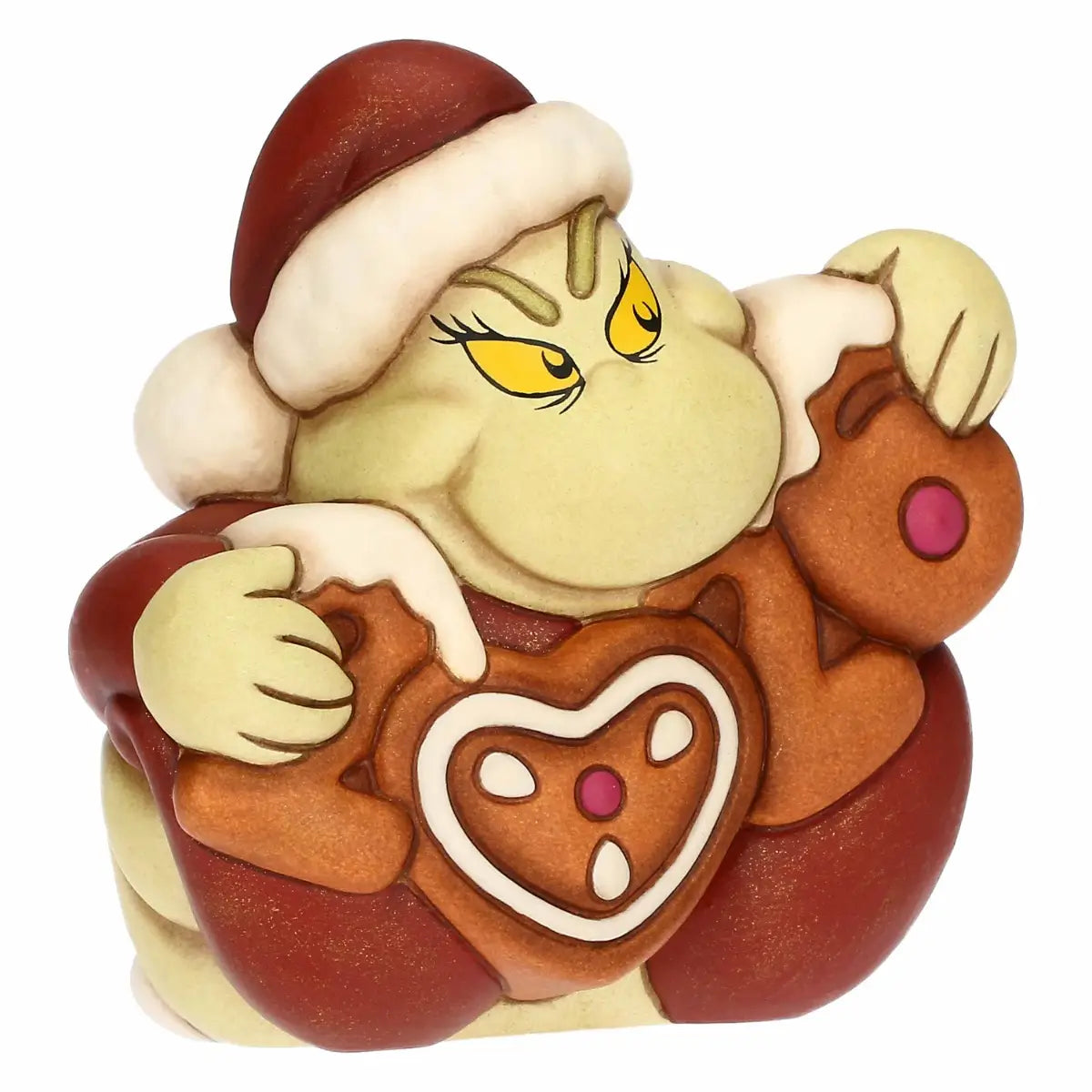 Questa statuina in ceramica ritrae il Grinch in una posa festiva ma coerente con la sua tipica espressione burbera. Il personaggio, di colore verde chiaro, indossa un cappello natalizio rosso bordato di pelliccia bianca e tiene tra le braccia il numero 2026. Le cifre sono realizzate con uno stile che ricorda i biscotti di pan di zenzero, con tonalità marrone caldo e decorazioni in glassa bianca.