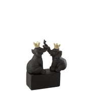 Statuina decorativa in resina scura raffigurante due elefanti seduti l'uno di fronte all'altro con le proboscidi intrecciate verso l'alto su una solida base rettangolare nera. Questa scultura da collezione presenta preziosi dettagli dorati grazie alle corone regali posizionate sulla testa dei due animali, rendendola un perfetto soprammobile portafortuna ed elegante elemento d'arredo per la casa.