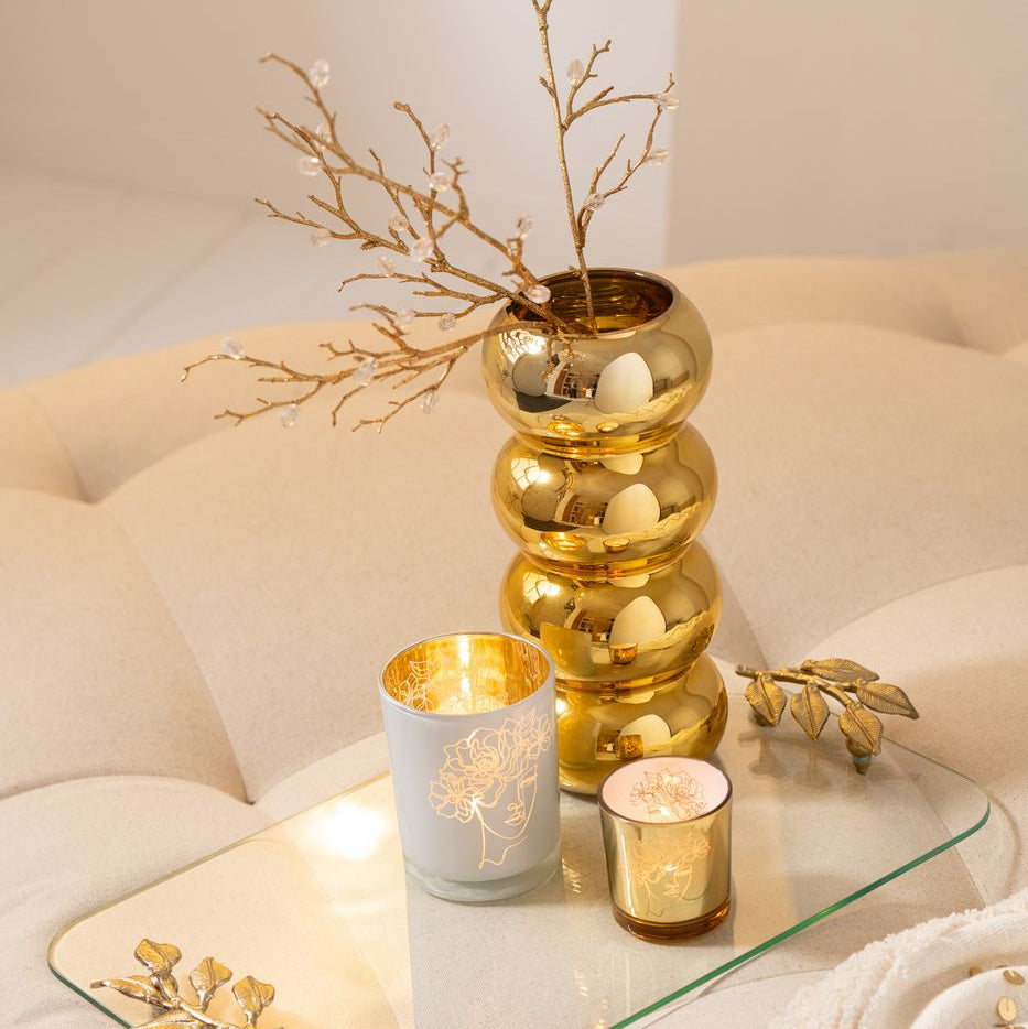 Vaso Bruco dorato con una lussuosa finitura metallica lucida a effetto specchio, caratterizzato da uno sviluppo verticale slanciato e un design moderno a quattro moduli sferici sovrapposti. Questo elegante complemento d'arredo per interni si sviluppa con una caratteristica forma sagomata a onde, ideale sia come vaso per fiori a stelo lungo sia come elemento decorativo di design per impreziosire la casa.