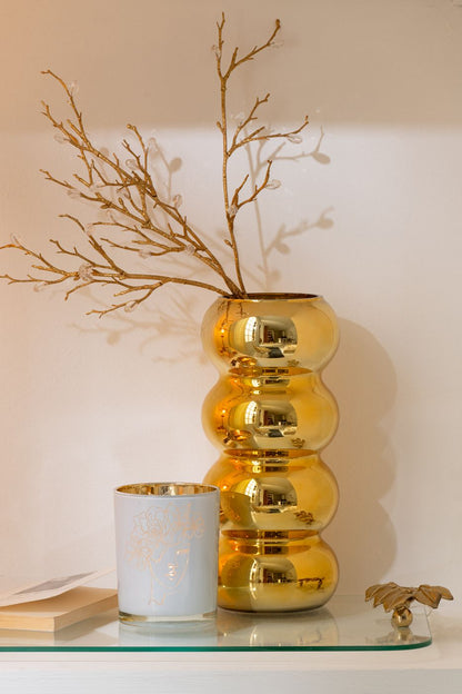 Vaso Bruco dorato con una lussuosa finitura metallica lucida a effetto specchio, caratterizzato da uno sviluppo verticale slanciato e un design moderno a quattro moduli sferici sovrapposti. Questo elegante complemento d'arredo per interni si sviluppa con una caratteristica forma sagomata a onde, ideale sia come vaso per fiori a stelo lungo sia come elemento decorativo di design per impreziosire la casa.