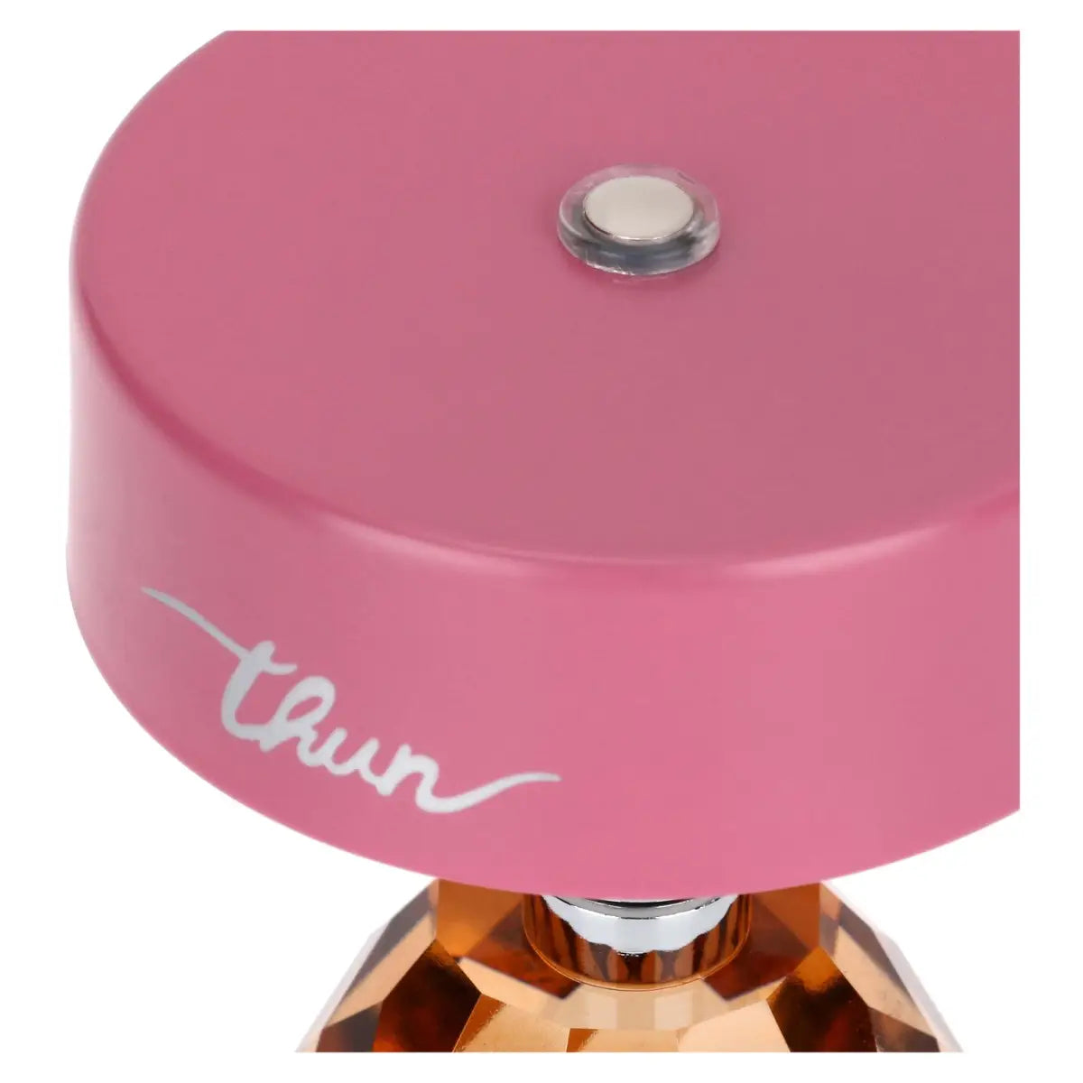 Vista ravvicinata dall'alto del paralume rosa; al centro della parte superiore è visibile un piccolo pulsante metallico circolare con bordo trasparente, utilizzato per l'accensione e la regolazione.