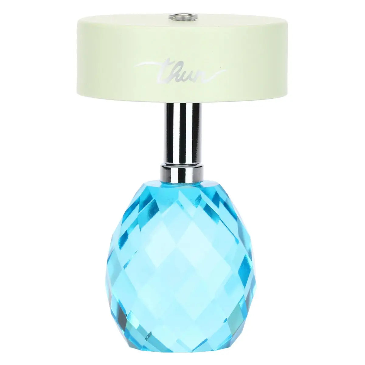 Lampada da tavolo ricaricabile Thun con paralume cilindrico color verde chiaro e base in cristallo sfaccettato a forma di uovo color azzurro. Lo stelo che unisce i due elementi è in metallo cromato e sul paralume è presente il logo Thun argentato.