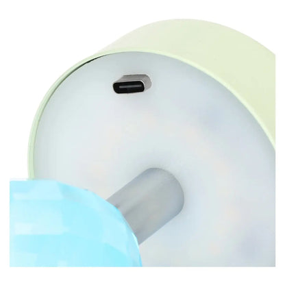 Dettaglio inferiore di lampada ricaricabile Thun azzurra e verde: si distinguono la porta di ricarica USB-C, il pannello LED circolare e lo stelo cromato con cristallo sfaccettato.
