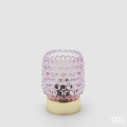 La lampada da tavolo Bubbles di Enzo De Gasperi (EDG) si distingue per un design raffinato che unisce un diffusore in vetro trasparente rosa con un caratteristico motivo a rilievo a bolle e una base cilindrica in metallo dalla finitura dorata lucida. La particolare lavorazione del vetro permette alla luce di rifrangersi nell'ambiente in modo suggestivo, rendendo l'oggetto ideale come punto luce d'accento per spazi in stile Modern Luxury o Glamour.