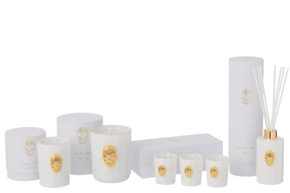 Collezione completa di candele profumate e diffusore d'ambiente a bastoncini della linea "Nuit Blanche" firmata Jolipa, caratterizzata da eleganti boccette e bicchieri in vetro bianco lucido impreziositi da un teschio dorato in rilievo. Questa esclusiva selezione di profumatori e candele decorative include scatole e confezioni regalo total white coordinate con dettagli in oro, perfetta come raffinata idea regalo o per impreziosire l'arredamento di interni moderni e di lusso.
