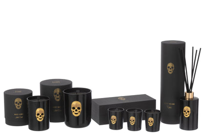 Collezione completa di candele profumate e diffusore d'ambiente a bastoncini "Cranio" Nuit Noire firmata Jolipa, caratterizzata da eleganti boccette e bicchieri in vetro nero lucido impreziositi da un teschio dorato in rilievo. Questa esclusiva linea di profumatori e candele decorative include scatole e confezioni regalo nere coordinate con dettagli in oro, perfetta come raffinata idea regalo o per impreziosire l'arredamento di interni moderni e di lusso.