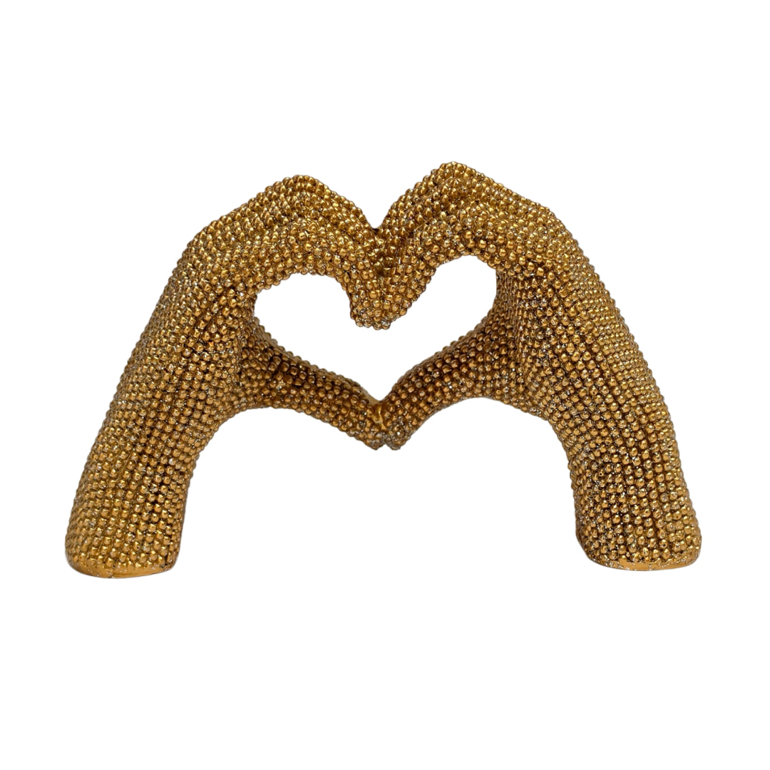 Statuina in resina raffigurante due mani dorate intrecciate a formare un cuore, interamente ricoperte di brillantini glitterati dall'effetto scintillante. Oggetto decorativo firmato Sud Import, ideale come soprammobile romantico o idea regalo per San Valentino e occasioni speciali.