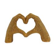 Statuina in resina raffigurante due mani dorate intrecciate a formare un cuore, interamente ricoperte di brillantini glitterati dall'effetto scintillante. Oggetto decorativo firmato Sud Import, ideale come soprammobile romantico o idea regalo per San Valentino e occasioni speciali.