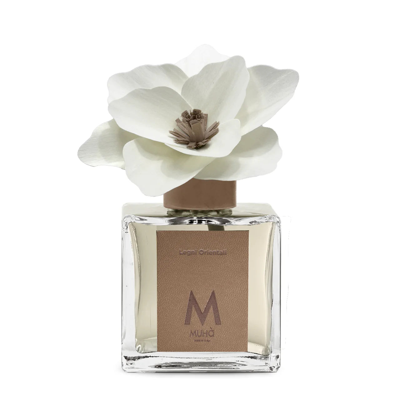 Profumatore d'ambiente Muhà Magnolia: flacone quadrato in vetro trasparente con essenza Legni Orientali e scenografico fiore in betulla color panna.