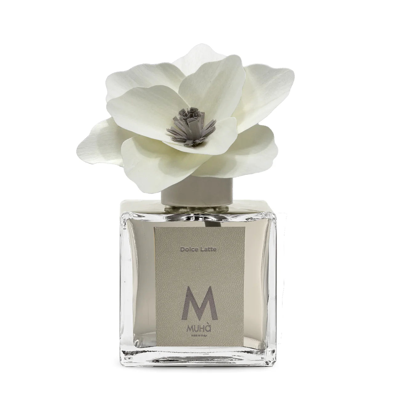 Profumatore d'ambiente Muhà Magnolia: flacone quadrato in vetro trasparente con essenza Dolce Latte e scenografico fiore in betulla bianco.