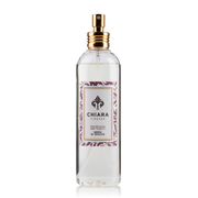Fragranza spray per tessuti in flacone di vetro trasparente con erogatore dorato, etichetta decorata con motivo botanico a rami e foglie viola "Nero di Bacco" firmata Chiara Firenze. Profumatore per tessuti elegante con logo a giglio, ideale per rinfrescare la casa o come idea regalo raffinata.