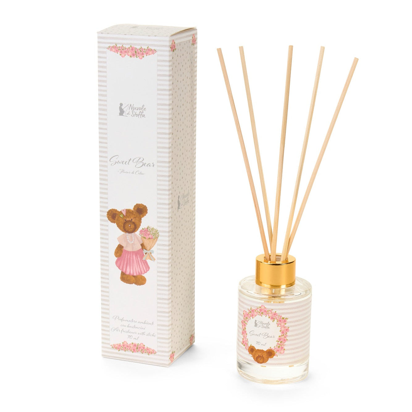 Profumatore per ambienti con bastoncini della collezione "Sweet Bear" di Nuvole di Stoffa, completo di boccetta in vetro da 70 ml e confezione regalo coordinata. Il diffusore presenta una delicata trama a righe bianche e rosa con l'illustrazione di un tenero orsetto e una ghirlanda di fiori, rifinito da una ghiera dorata, ideale per profumare e decorare le camerette dei bambini o come idea regalo.