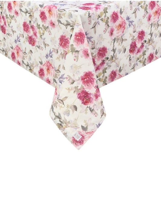 Inquadratura ravvicinata dell'angolo di una tovaglia beige con stampa floreale di peonie rosa e fucsia. Il tessuto cade morbidamente mostrando il pattern continuo di fiori e foglie grigie e lilla.