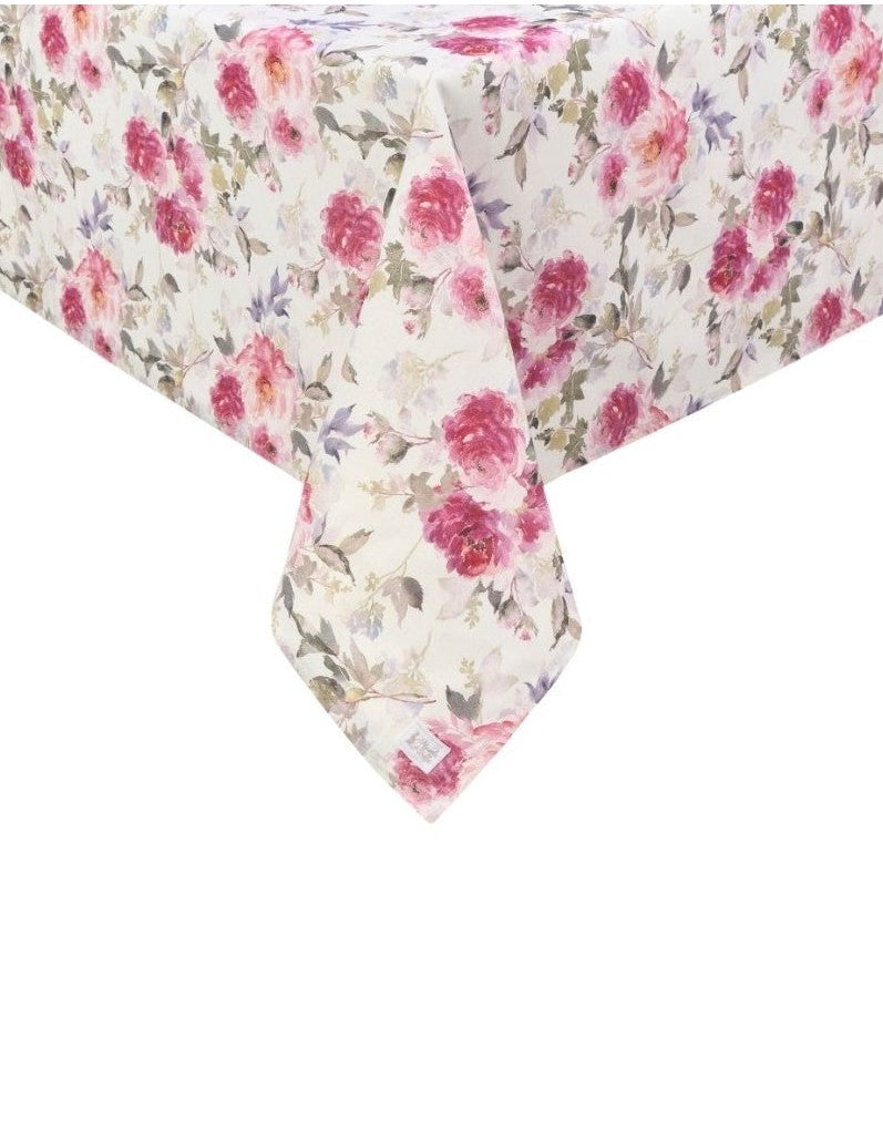 Inquadratura ravvicinata dell'angolo di una tovaglia beige con stampa floreale di peonie rosa e fucsia. Il tessuto cade morbidamente mostrando il pattern continuo di fiori e foglie grigie e lilla.