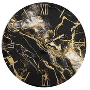 Orologio da parete circolare modello "Fluido" di Artidea. Il quadrante presenta un design drammatico a effetto marmo nero con venature bianche e ampie colate color oro che creano un contrasto dinamico. Numeri romani e indici lineari in metallo dorato lucido sono applicati a rilievo sul quadrante, coordinati con le lancette sottili dorate.