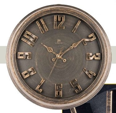 Orologio da parete circolare Justaminute con finitura bronzo anticato. Il quadrante scuro presenta una texture spazzolata circolare su cui risaltano grandi numeri arabi a rilievo in metallo bronzato. Le lancette coordinate sono sagomate in stile classico. Design robusto con cornice spessa, ideale per un arredamento industrial o rétro.
