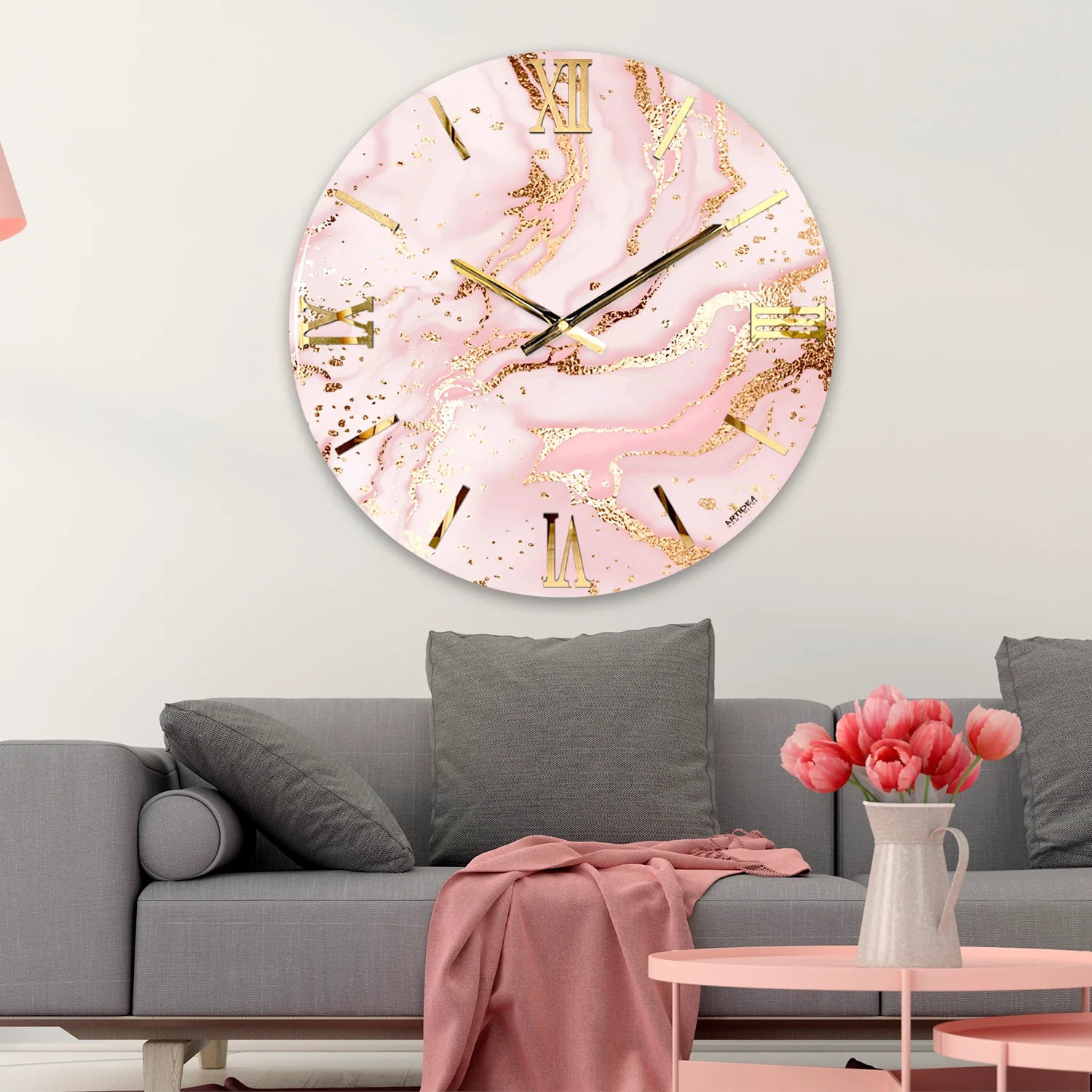 Orologio da parete circolare Artidea modello Pink, diametro 60 cm. Design artistico effetto marmo con venature fluide in rosa pastello e spruzzi di foglia oro, numeri romani e lancette minimaliste in metallo dorato.