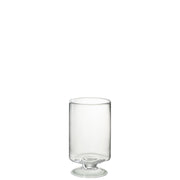 Un portacandela in vetro trasparente, dal design lineare e cilindrico, sostenuto da una piccola base a piede che ne dona stabilità ed eleganza. Le pareti lisce e sottili lasciano trasparire completamente la fiamma, esaltandone la luminosità. Un accessorio dal gusto minimale e raffinato, perfetto come portacandela o lanterna decorativa per la tavola e gli ambienti living.