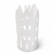 Porta Bicchieri cilindrico in metallo bianco traforato, con bordi sagomati a forma di casette con finestre a cuore alternate ad alberi stilizzati. Complemento da tavola dal design romantico, ideale per apparecchiare con stile o come idea regalo per la casa.