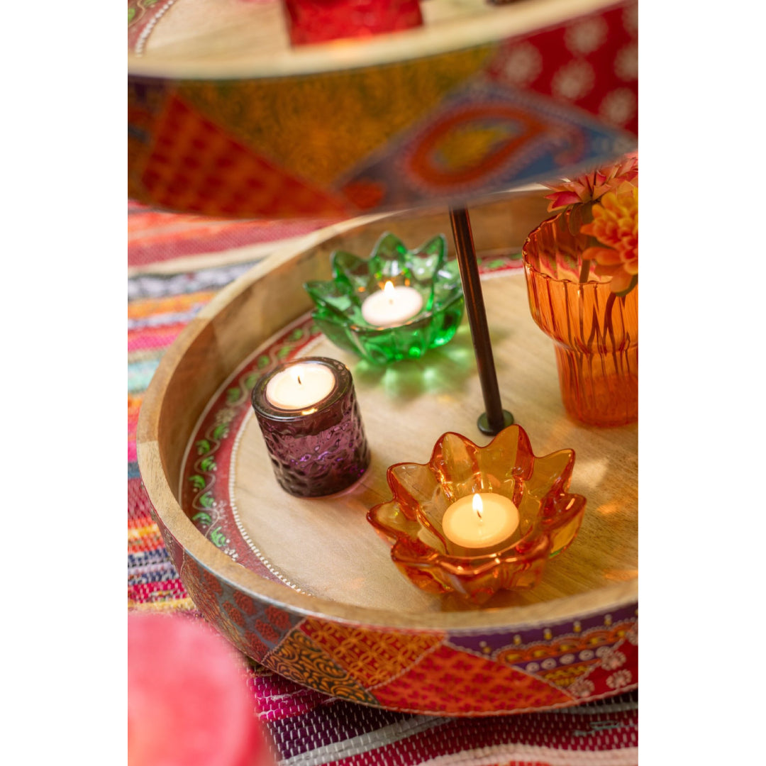 Portacandele a forma di fiore in vetro colorato assortiti firmati Jolipa, caratterizzati da petali sagomati e sfaccettati che creano eleganti riflessi di luce con le candele tea light. Disponibili nelle vivaci varianti trasparente rosa, ambra e verde, questi piccoli candelabri decorativi di design sono perfetti per abbellire la tavola, creare atmosfera negli interni o come colorata idea regalo home decor.