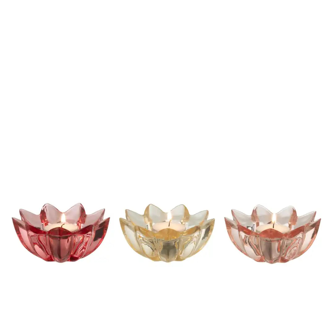 Portacandele a forma di fiore in vetro colorato assortiti firmati Jolipa, caratterizzati da petali sagomati e sfaccettati che creano eleganti riflessi di luce con le candele tea light. Disponibili nelle vivaci varianti trasparente rosa pastello, crema e rosso, questi piccoli candelabri decorativi di design sono perfetti per abbellire la tavola, creare atmosfera negli interni o come colorata idea regalo home decor.