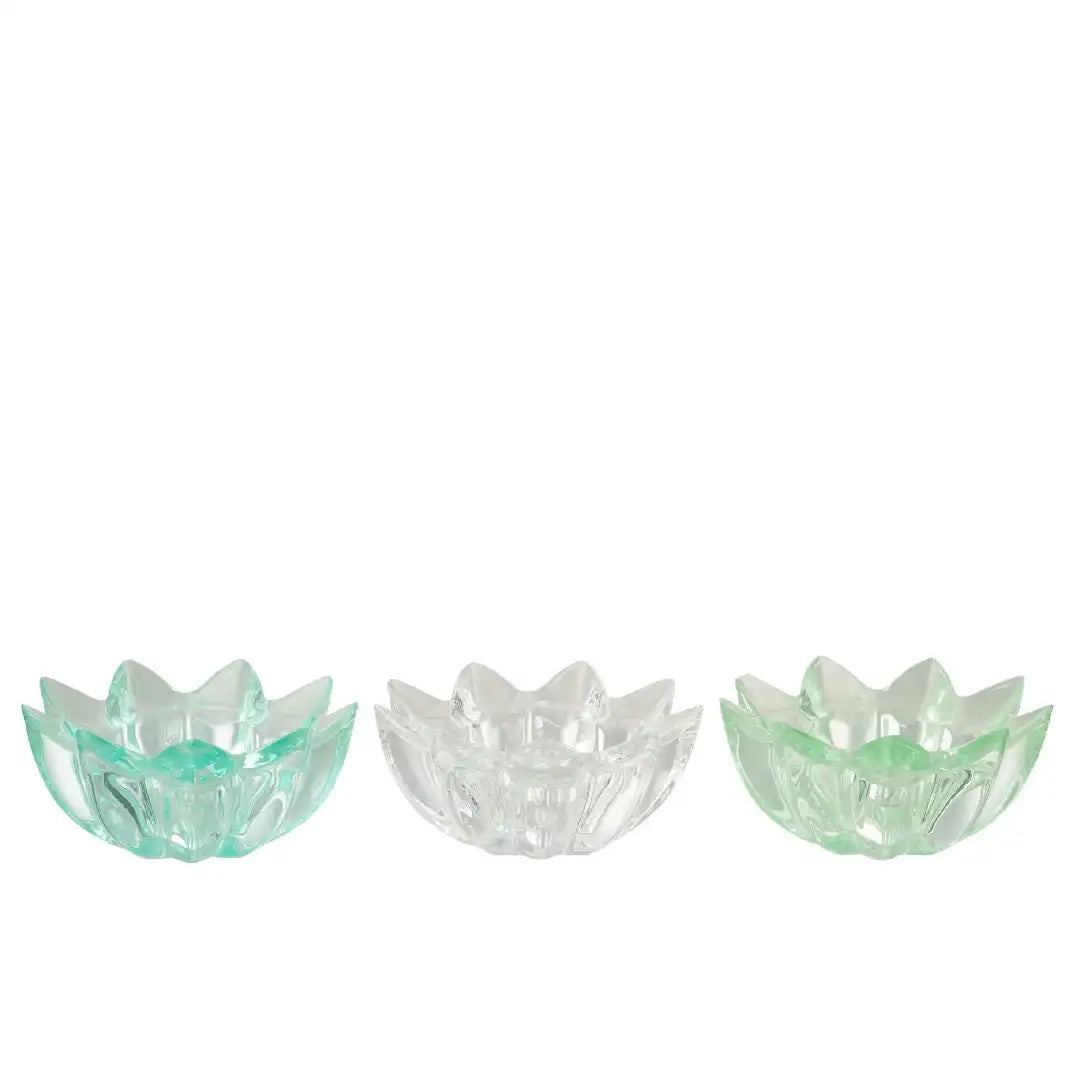 Portacandele a forma di fiore in vetro colorato assortiti firmati Jolipa, caratterizzati da petali sagomati e sfaccettati che creano eleganti riflessi di luce con le candele tea light. Disponibili nelle vivaci varianti trasparente celeste, bianco e verde, questi piccoli candelabri decorativi di design sono perfetti per abbellire la tavola, creare atmosfera negli interni o come colorata idea regalo home decor.