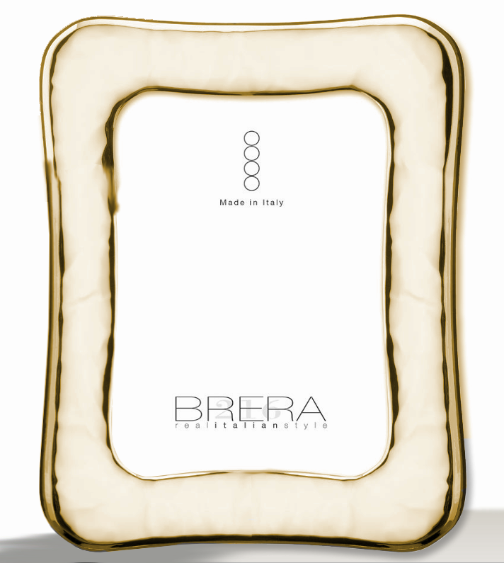 Portafoto da tavolo placcato oro bilaminato lucido con cornice sagomata e profilo ondulato. La superficie è caratterizzata da una lavorazione "stropicciata" o a effetto martellato morbido che crea riflessi luminosi dinamici. L'inserto centrale bianco riporta il marchio "BRERA real italian style" e la certificazione "Made in Italy".