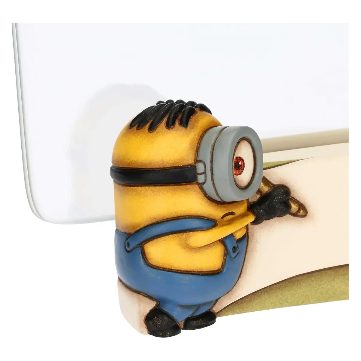 Cornice portafoto in ceramica Thun con personaggio Minion in rilievo. La base della cornice presenta un Minion con salopette azzurra intento a scrivere su una pergamena bianca, affiancato da due palloncini colorati. Design iconico Thun applicato al mondo dei Minions, ideale per camerette o come idea regalo originale.
