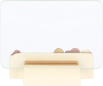 Il Portafoto con Cuori Thun presenta una base in ceramica decorata con cuori in rilievo e un'elegante lastra di vetro trasparente per esporre i tuoi ricordi più cari. Questo complemento d'arredo riflette lo stile inconfondibile del marchio Thun, ideale come preziosa idea regalo o come cornice decorativa per impreziosire la tua casa.