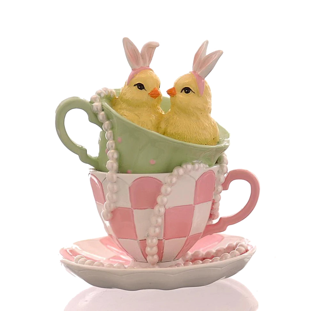 Decorazione pasquale Vetur in poliresina h 14 cm. Due pulcini gialli con cerchietto da coniglio seduti in tazzine da tè sovrapposte (una verde a pois e una rosa a scacchi). Dettaglio con collana di perle.