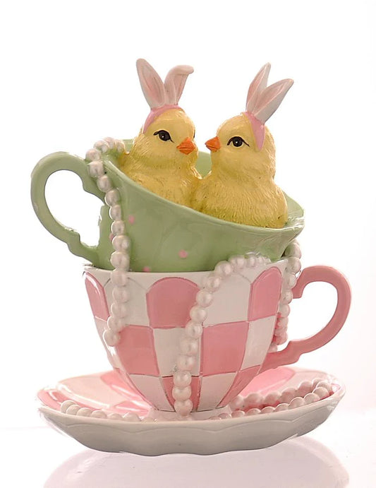 Decorazione pasquale Vetur in poliresina h 14 cm. Due pulcini gialli con cerchietto da coniglio seduti in tazzine da tè sovrapposte (una verde a pois e una rosa a scacchi). Dettaglio con collana di perle.