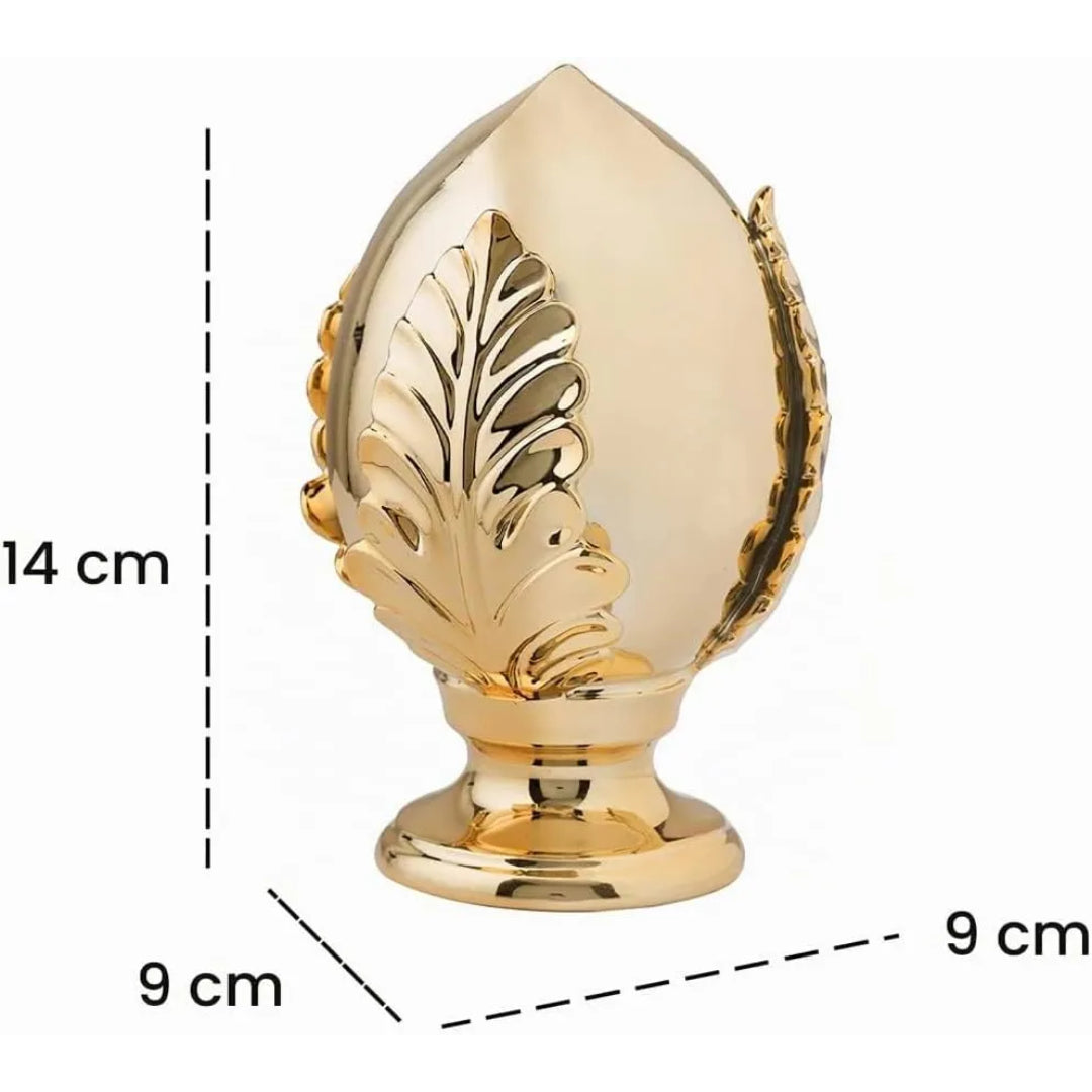 Pumo decorativo in ceramica dorata dalla tipica forma pugliese a goccia, con foglia intagliata in rilievo sul fronte e base tornita, disponibile in set da più pezzi in diverse dimensioni. Oggetto d'arredo dalla tradizione mediterranea firmato Montemaggi, ideale come soprammobile o idea regalo raffinata.