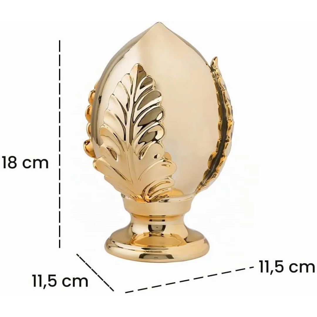 Pumo decorativo in ceramica dorata dalla tipica forma pugliese a goccia, con foglia intagliata in rilievo sul fronte e base tornita, disponibile in set da più pezzi in diverse dimensioni. Oggetto d'arredo dalla tradizione mediterranea firmato Montemaggi, ideale come soprammobile o idea regalo raffinata.